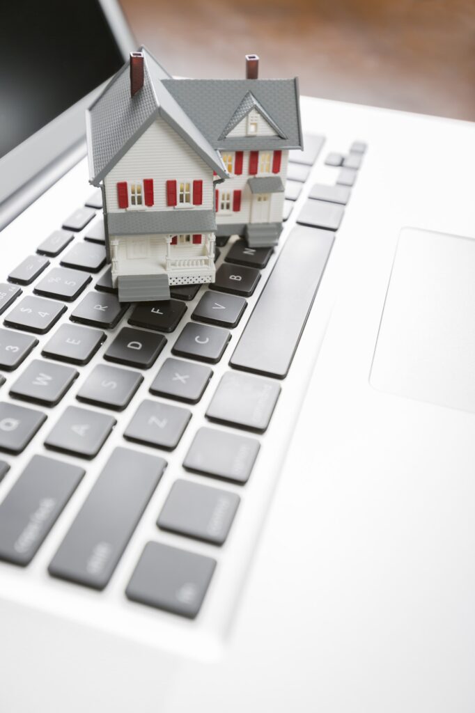 Miniature House on Laptop Computer